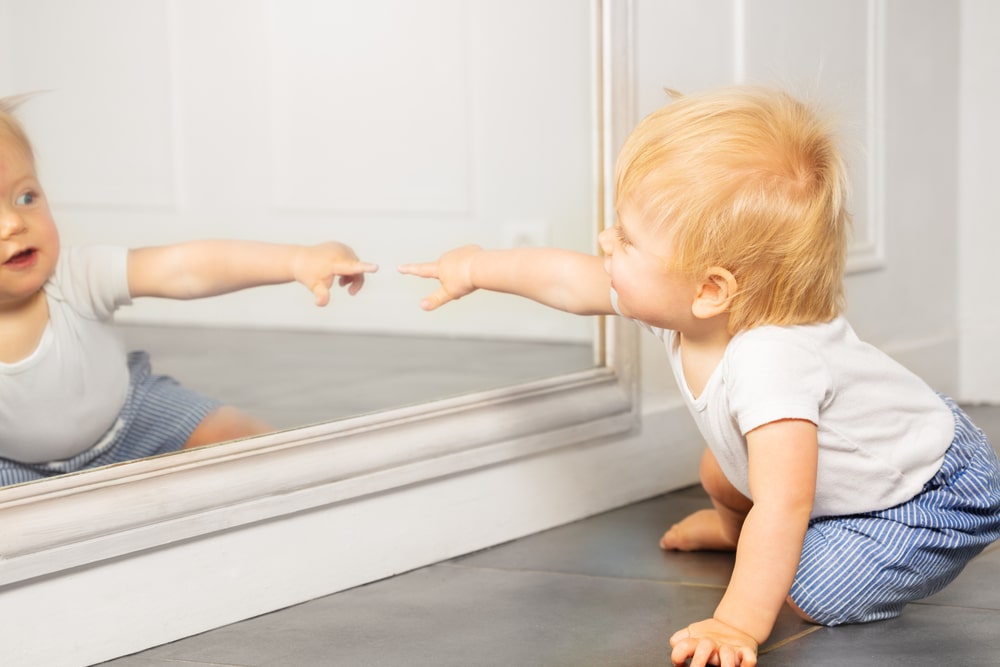 Bébé jouant avec un Miroir Montessori